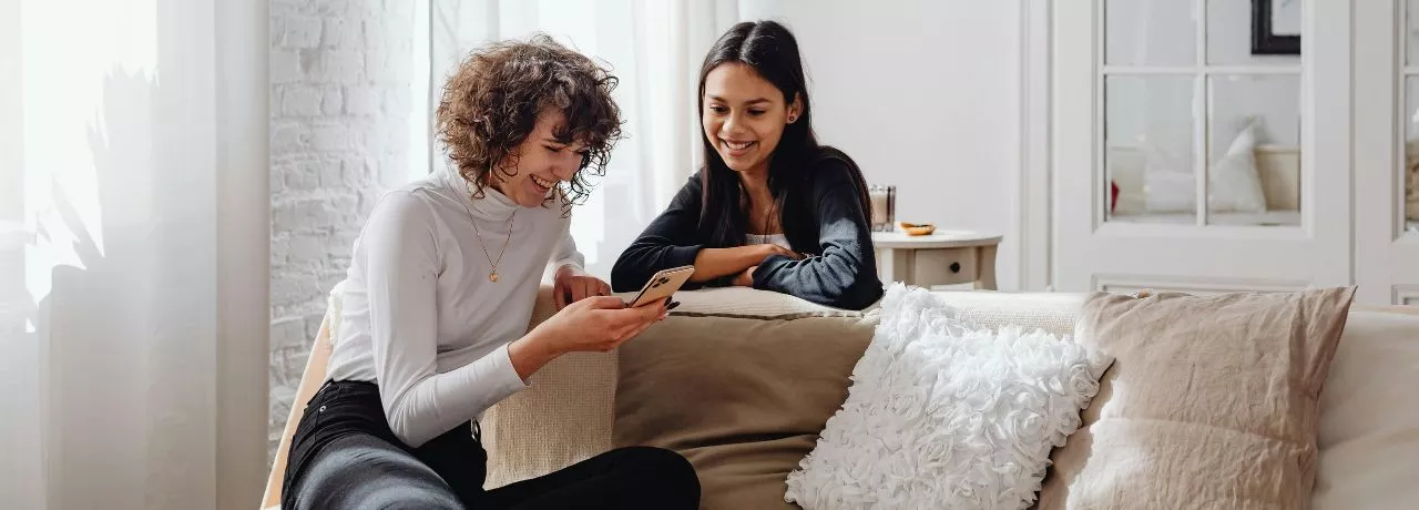 due amiche che guardano insieme lo schermo del cellulare, simbolo di benessere 