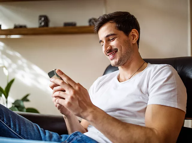 Immagine di un ragazzo con in mano lo smartphone simboleggia la possibilità di utilizzare i Buoni Acquisto Pluxee su siti e-commerce