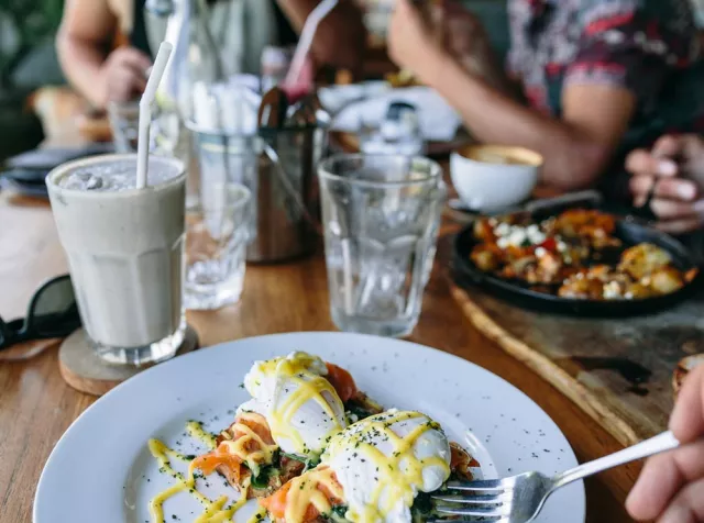 L’immagine di una tavola imbandita con persone che mangiano rappresenta l’utilizzo da parte dei dipendenti dei Buoni Pasto Cartacei Pluxee per la pausa pranzo.