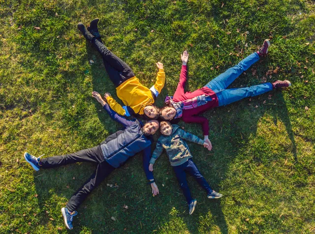 Immagine di una bambina sdraiata sul prato. Simboleggia l’impegno di Pluxee nell’aiutare le persone a fare scelte sostenibili