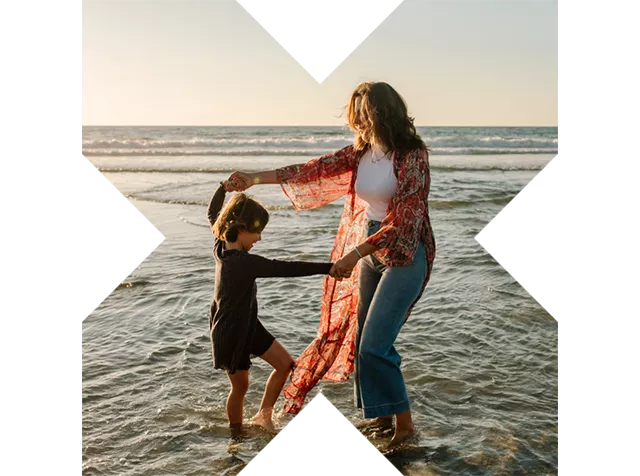 Madre e figlio danzano felici in riva al mare