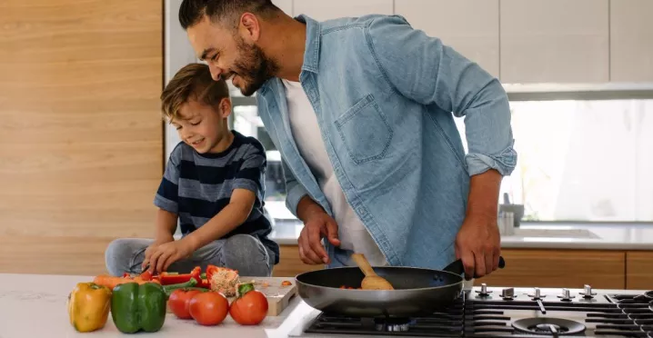 Concetto di buoni pasto e salute: padre e figlio cucinano insieme