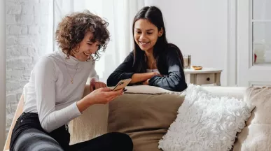 due amiche che guardano insieme lo schermo del cellulare, simbolo di benessere