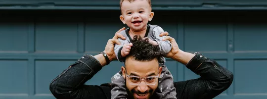 Immagine di un papà con un bambino sulle spalle mentre ridono. Rappresenta la sezione dedicata al Club esclusivo riservato agli utilizzatori ei Buoni Pasto Pluxee.
